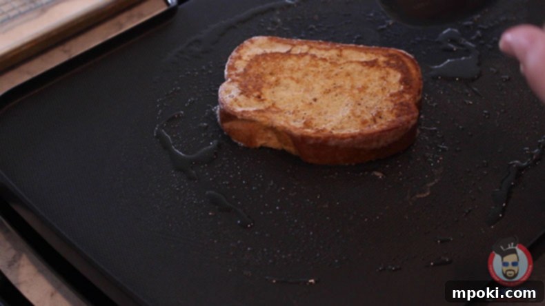 Dads Guide To Flawless French Toast 5 Three slices of golden French toast cooking on a large electric griddle, showing the ample space available.