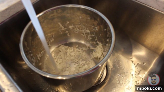 Five Best Instant Pot Secrets From a Dad 3 Warm water being poured into the stainless steel inner pot with dried leftover rice, demonstrating an effective cleaning hack.