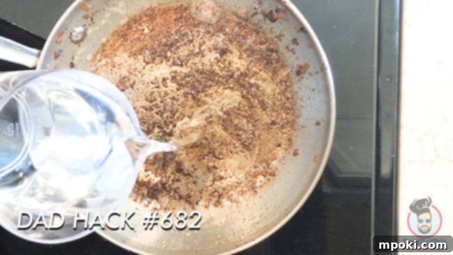 Five Best Instant Pot Secrets From a Dad 4 Water boiling in a stainless steel pan with caked-on residue, illustrating a powerful cleaning method for stubborn food.