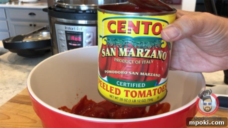 Instant Pot Italian Spaghetti: Weeknight Wonder 3 A can of Cento San Marzano Peeled Plum Tomatoes, certified DOP, rests over a working bowl with an Instant Pot visible in the background, ready for authentic Italian sauce preparation.
