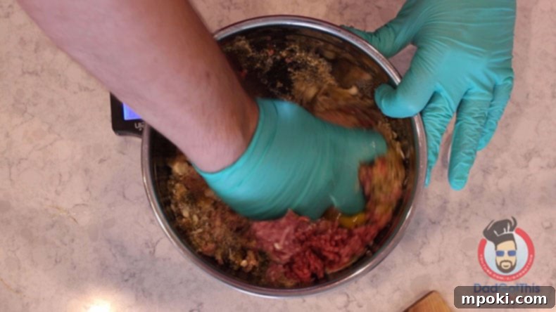 Authentic Italian Meatballs from Scratch 3 A gloved hand expertly mixing ground beef and pork with spices in a large silver bowl, preparing homemade Italian meatballs.