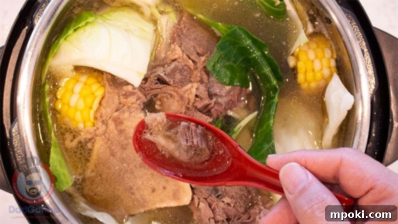 Easy Instant Pot Bulalo 2 A soup spoon over and Instant Pot with Beef Bulalo Soup in it.