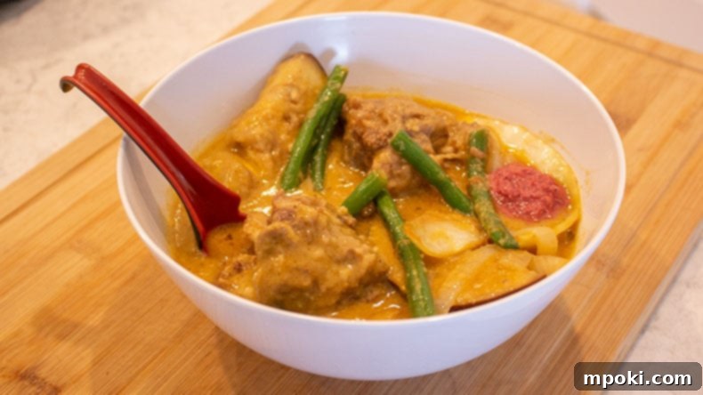 Effortless Instant Pot Kare Kare Filipino Classic Made Simple 2 A bowl on instant pot kare kare with a red spoon