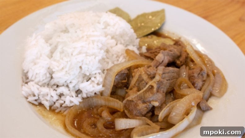 Delicious Instant Pot Pork Bistek Tagalog 2 pork bistek tagalog on a white plate with white rice