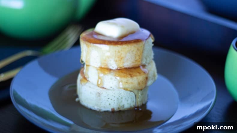 Dad Makes Amazing Japanese Pancakes 2 Three perfectly stacked, fluffy Japanese pancakes on a black plate, ready to be served.