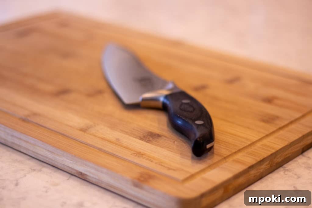 Wood Or Plastic The Ultimate Cutting Board Decision 3 Bamboo Cutting Board with a Knife on it, ideal for cooked meats and vegetables