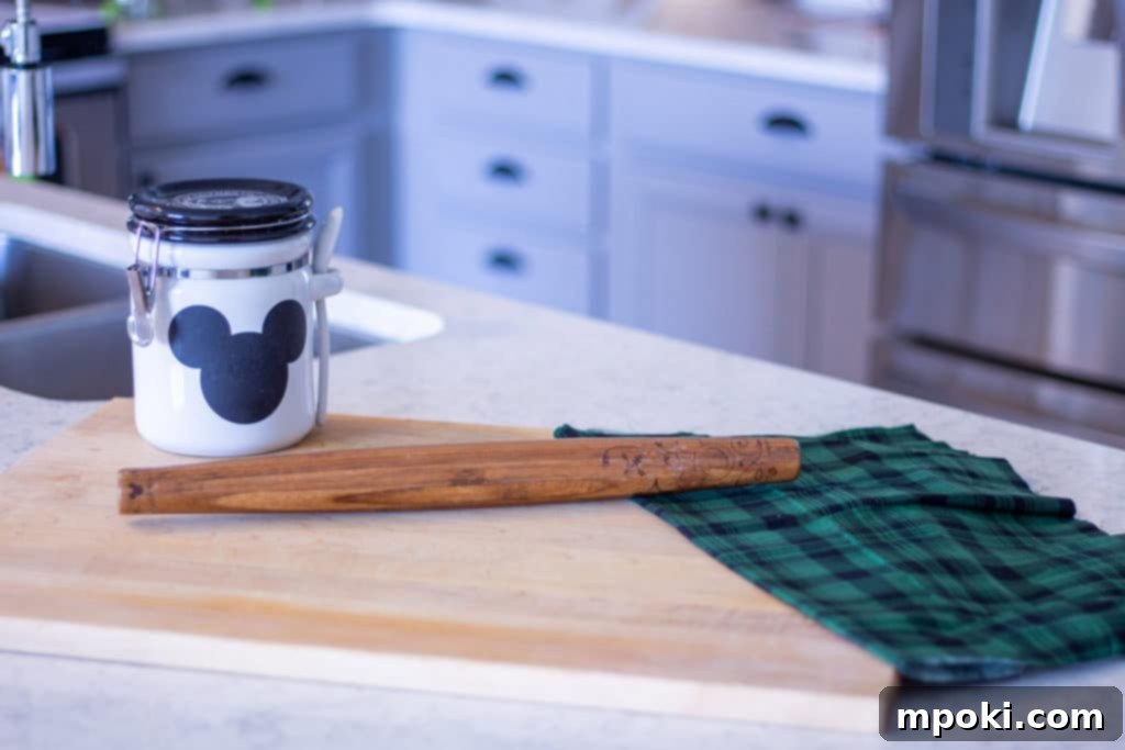 Wood Or Plastic The Ultimate Cutting Board Decision 5 a large wood cutting board on a counter with a jar and a rolling pin, perfect for baking
