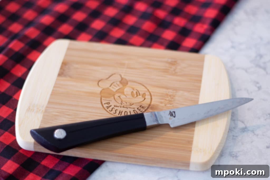 Wood Or Plastic The Ultimate Cutting Board Decision 6 a small cutting board with mickey logo and a knife, perfect for quick, light tasks