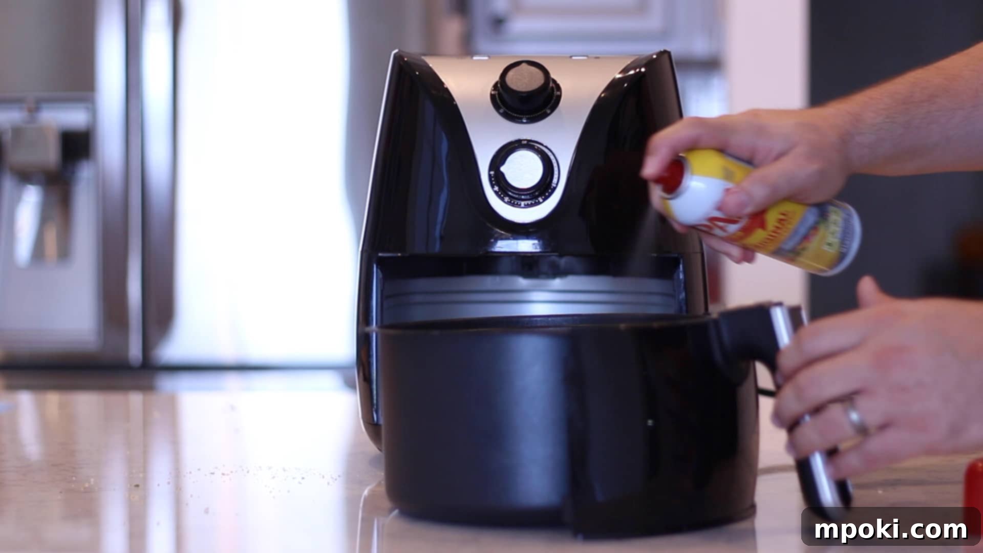 Crab-Stuffed Mushrooms: Air Fryer and Oven Delights 11 spraying crab stuffed mushrooms in an air fryer basket with pam