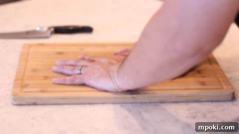 Anchor Your Cutting Board for a Steady Slice 7 hands pressing down on a cutting board