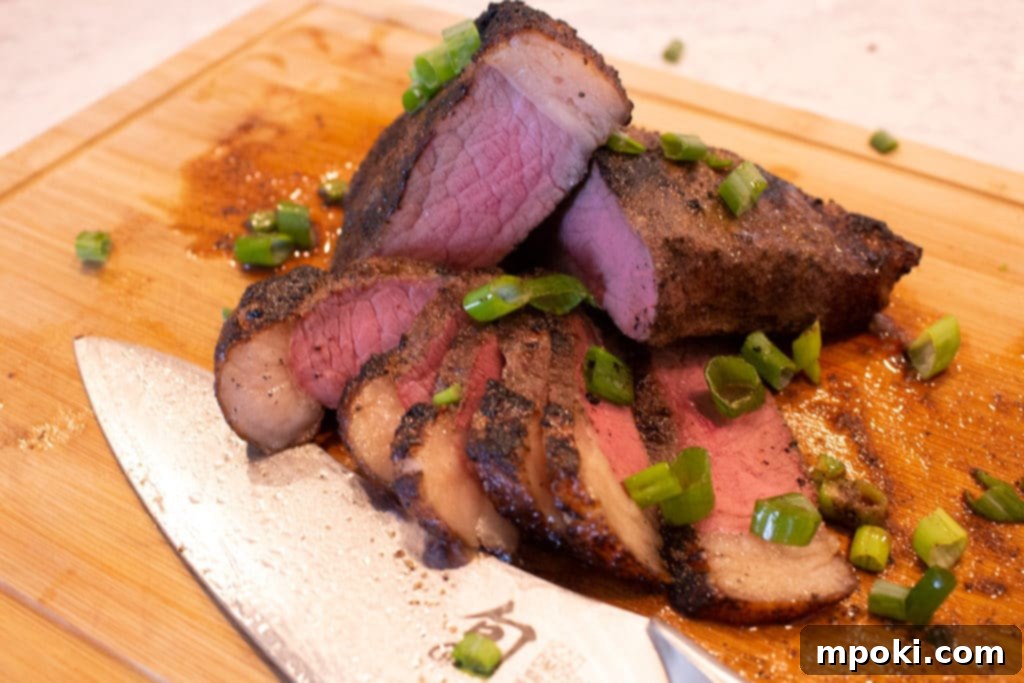 Sous Vide Simplified Your Essential Guide 6 A sliced medium rare picanha steak on a wooden cutting board with a knife