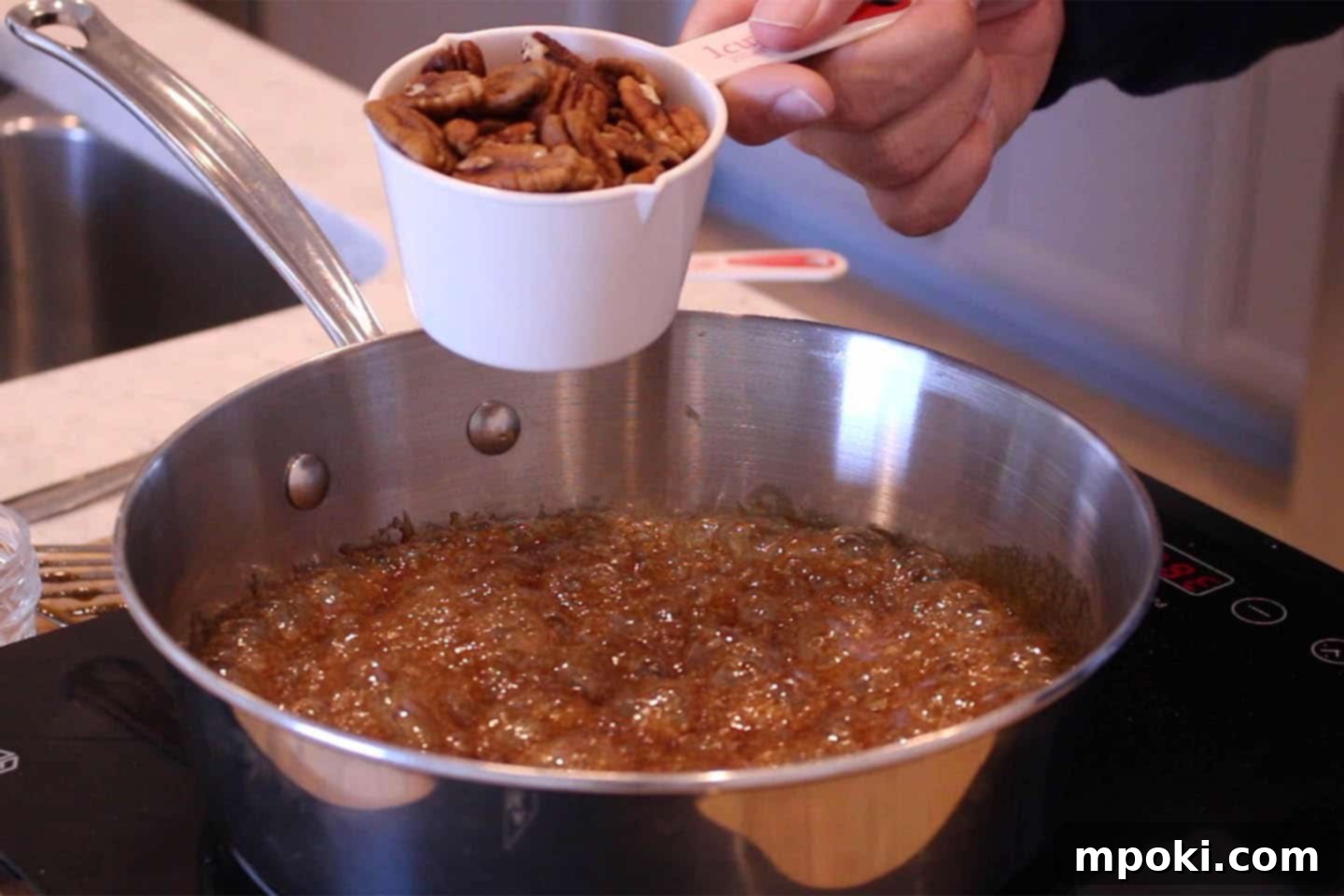 Delicious 5 Minute Candied Pecans 5 Pecans being tossed in the bubbling sugar mixture to coat them