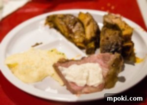 Mickey's Creamy Parmesan Mashed Potatoes 3 A dining table at Chef Mickey's showing a plate with a spoonful of whipped parmesan mashed potatoes
