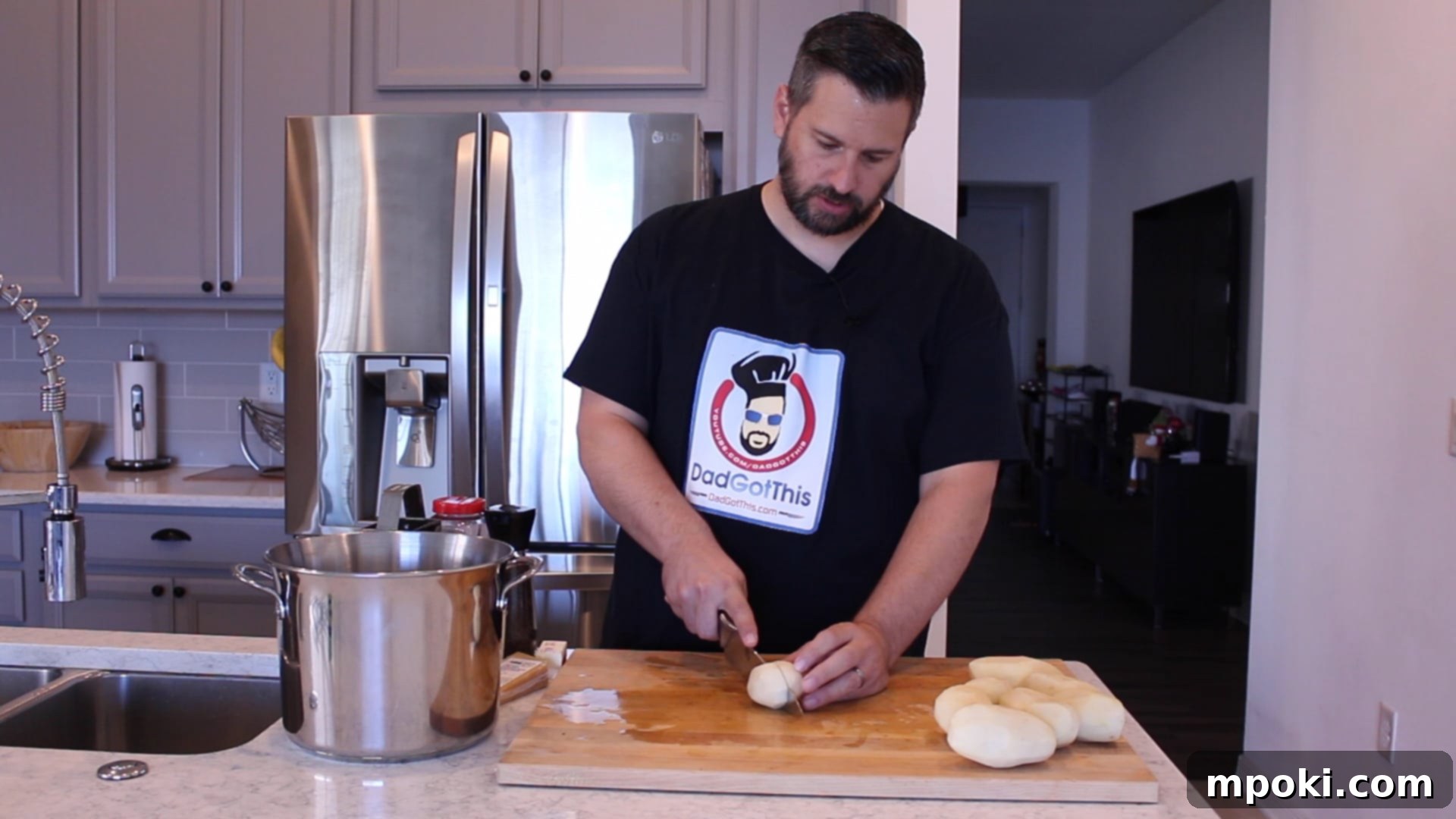 Mickey's Creamy Parmesan Mashed Potatoes 4 Hands peeling and cutting Russet potatoes into even chunks on a wooden cutting board