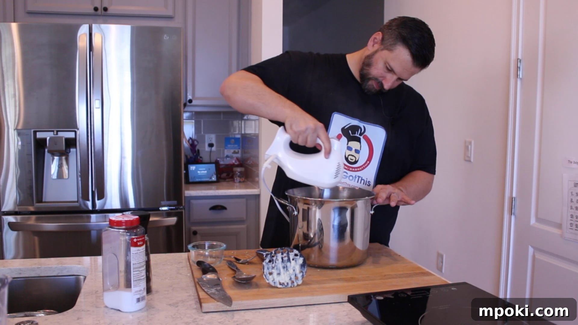 Mickey's Creamy Parmesan Mashed Potatoes 8 A person whipping mashed potatoes with a hand mixer in a large pot