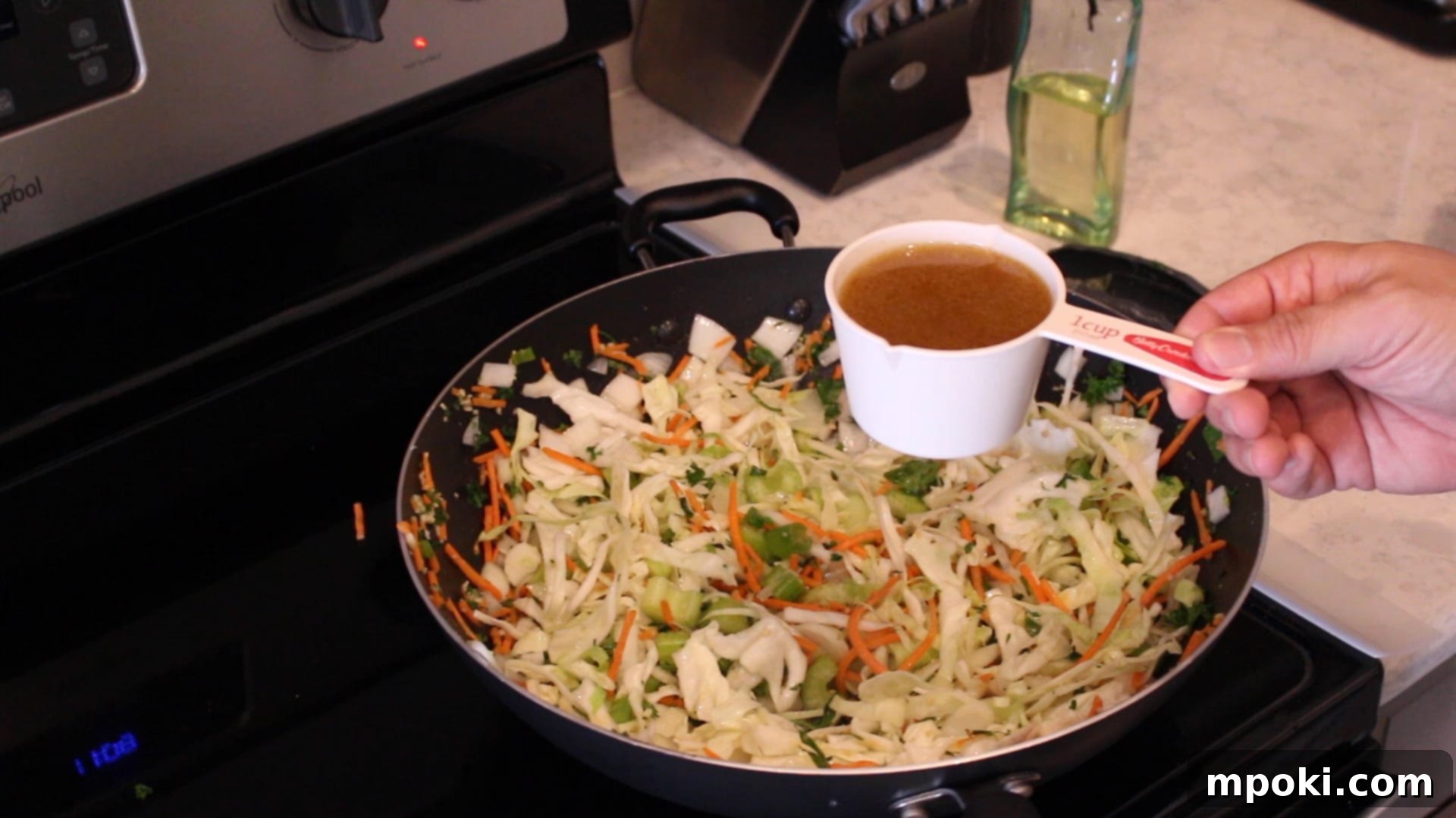 One-Pot Instant Pot Pancit Bihon 8 a measuring cup over a wok