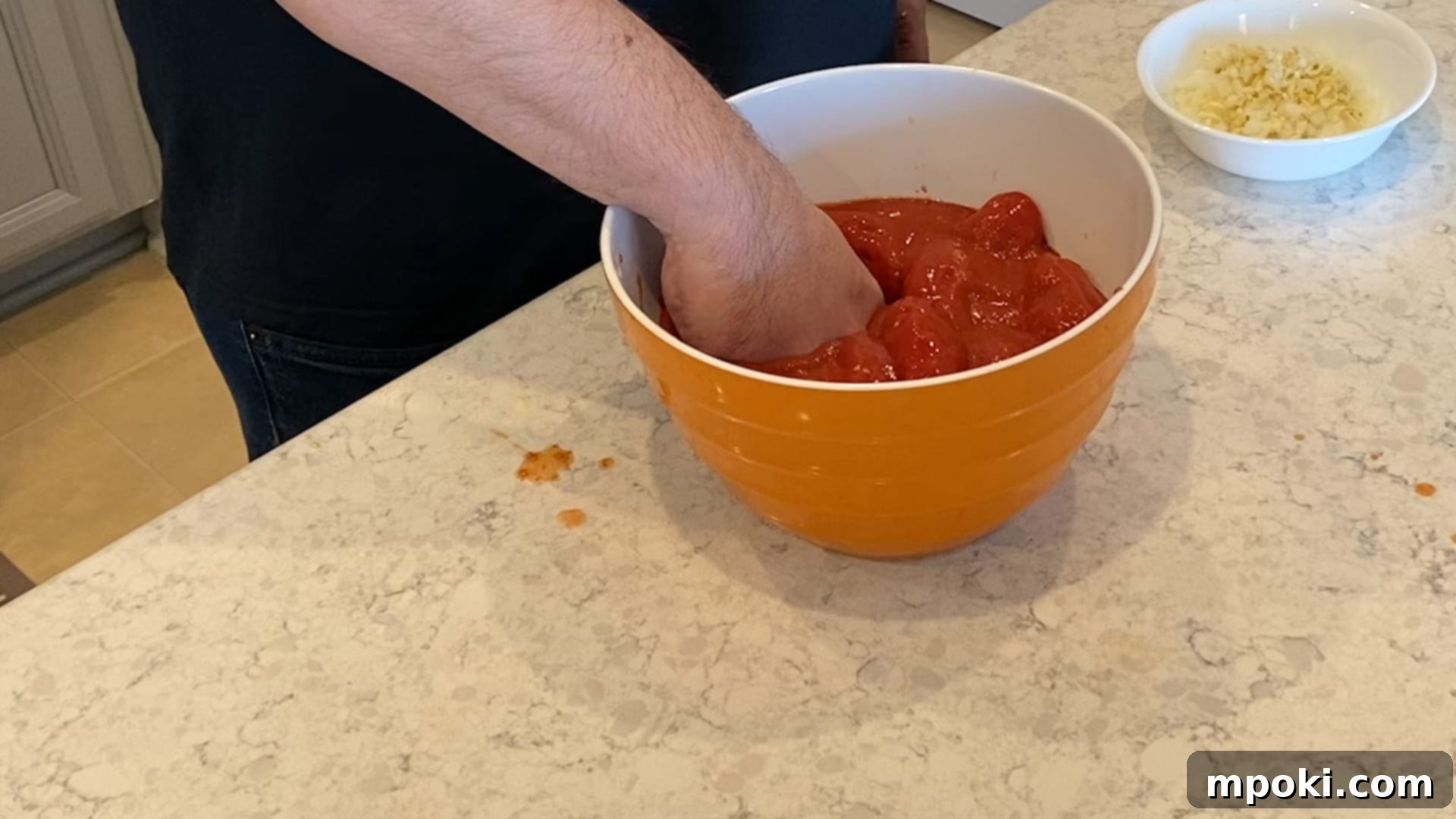 Effortless Homemade Meat Sauce 5 Crushing San Marzano tomatoes by hand in a bowl