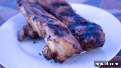 Charcoal Kissed Sous Vide Picanha 10 Spare Ribs that were Sous Vide then Grilled on a white plate, served as a main dish.