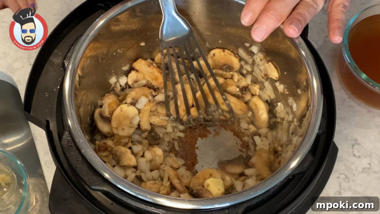 Quick and Creamy Instant Pot Beef Stroganoff 6 Scraping the bottom of the Instant Pot to deglaze after sautéing vegetables.
