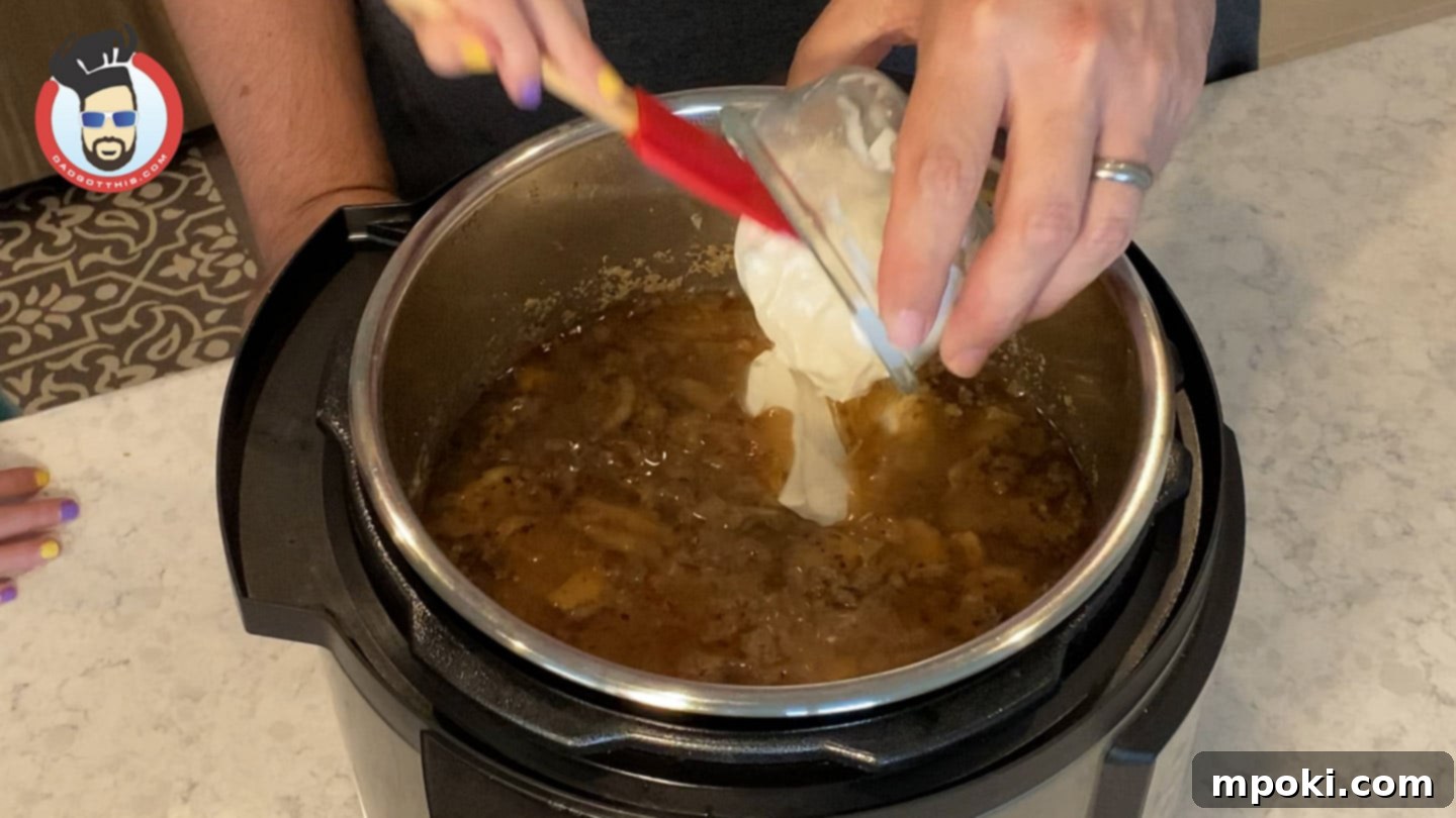 Quick and Creamy Instant Pot Beef Stroganoff 8 Stirring sour cream into the Instant Pot Beef Stroganoff after pressure cooking.