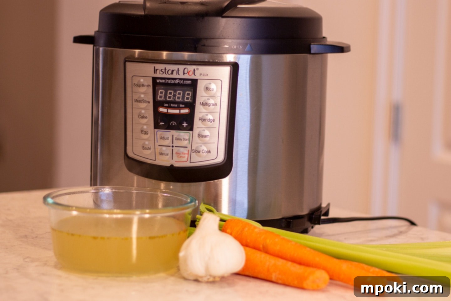 Homemade Instant Pot Chicken Broth 2 Rich homemade chicken broth in a bowl, ready to use, with an Instant Pot in the background.