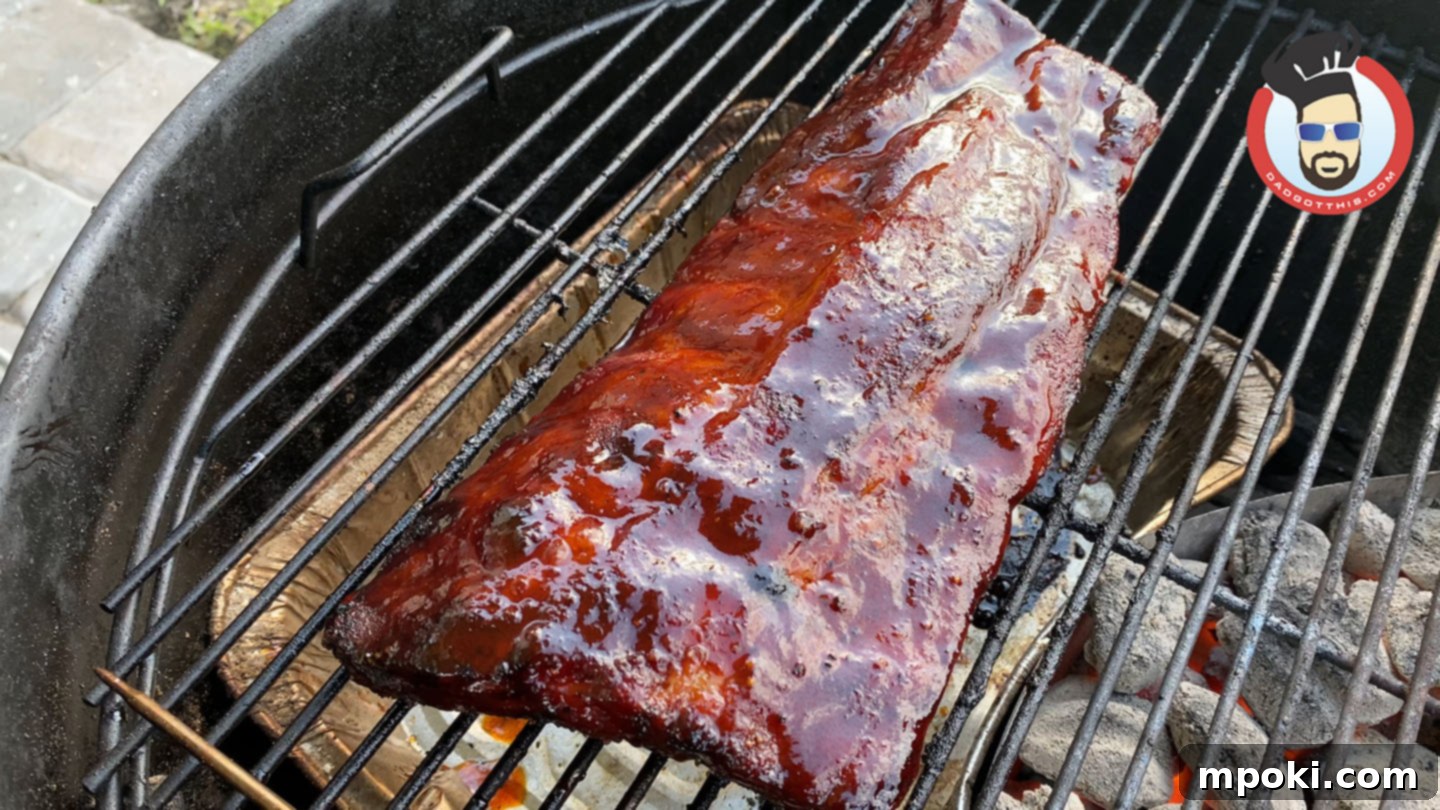 Slow Smoked Weber Kettle Ribs 6 Glazed ribs on a Weber Kettle grill, nearing completion