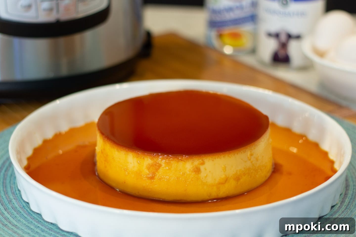 Authentic Leche Flan Quick Instant Pot Recipe 2 Lush, creamy Filipino Leche Flan drizzled with golden caramel, served on a white plate on a kitchen counter, ready to be enjoyed.