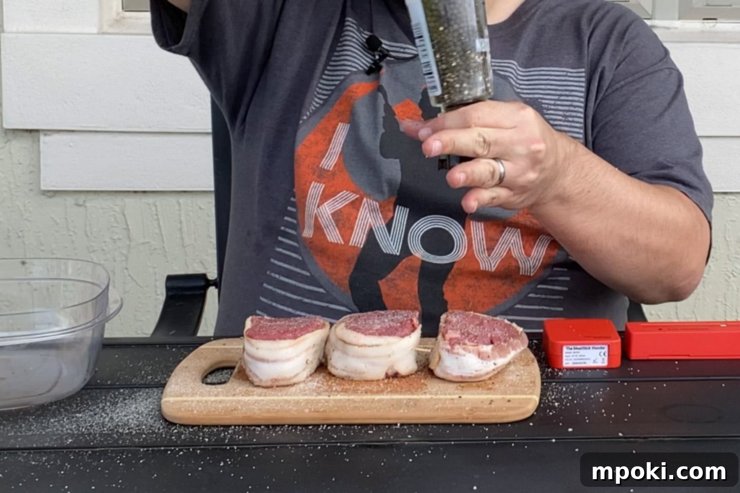 Reverse Seared Bacon Wrapped Filet Mignon on the Grill 4 Dad sesoning some steaks with pepper