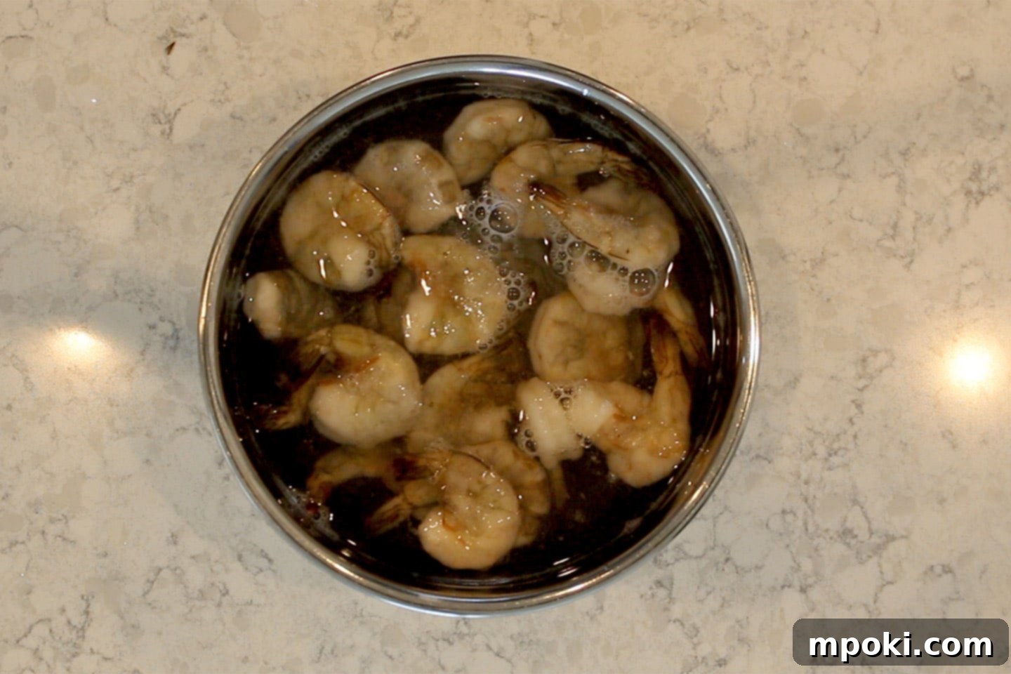 Your Go-To 30 Minute Shrimp Taco Dinner 3 Frozen shrimp thawing in a bowl of cold water, a quick and easy step for delicious shrimp tacos