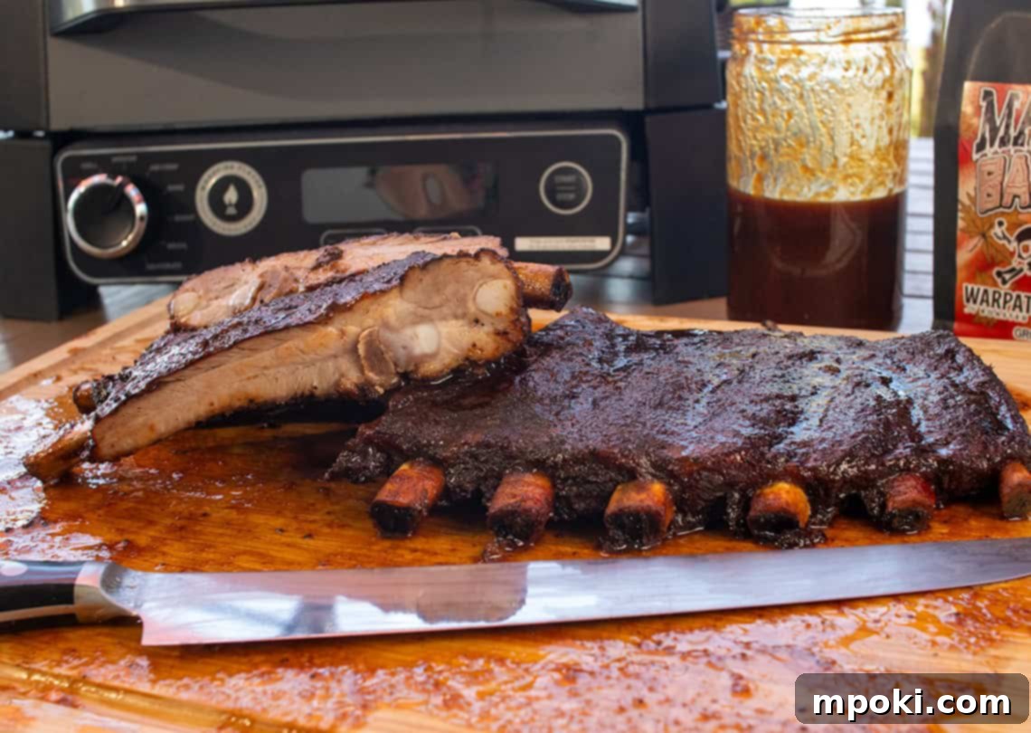 Maple Bacon Coffee Smoked Ribs on the Ninja Woodfire 2 Perfectly smoked ribs with a sticky glaze, sliced on a cutting board, ready to be served.