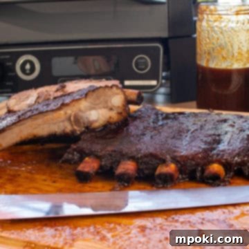 Maple Bacon Coffee Smoked Ribs on the Ninja Woodfire 3 Close-up of a rack of smoked ribs, showing the dark bark and glistening surface.