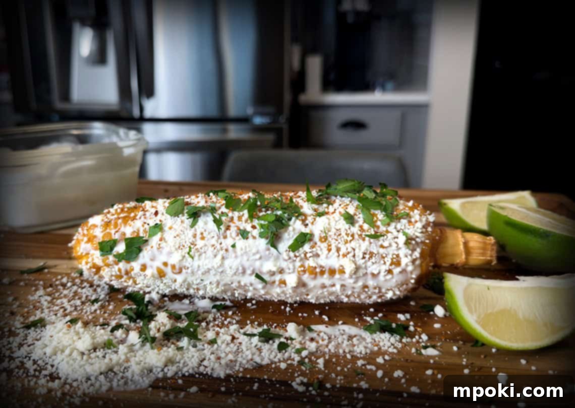 Smoky Ninja Woodfire Elote 2 Perfectly grilled Mexican Street Corn (Elote) on the Ninja Woodfire Grill, topped with cotija cheese and a lime wedge.